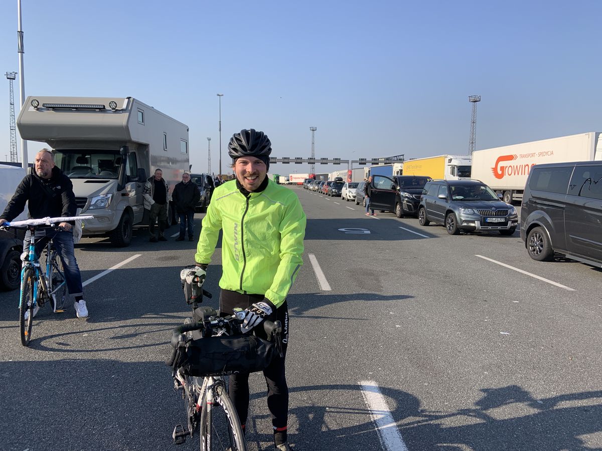 Ankunft im Fährhafen Rostock kurz vor der Überfahrt, lachend mit Helm und Rennrad
